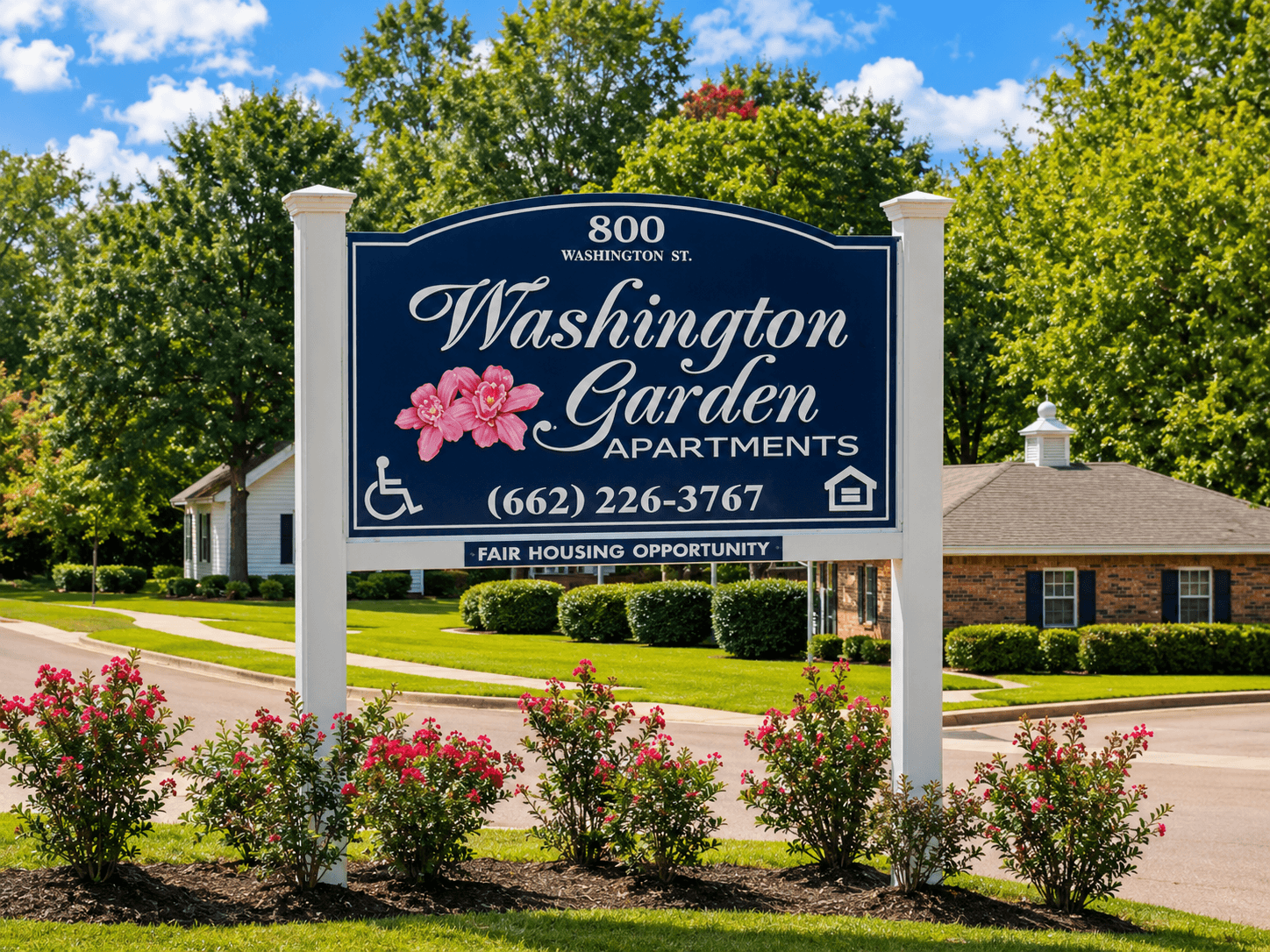 A sign for Washington Garden Apartments stands in front of a building.